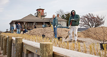 Volunteers Keith and Louise Clark plant beach plums along completed bulkhead